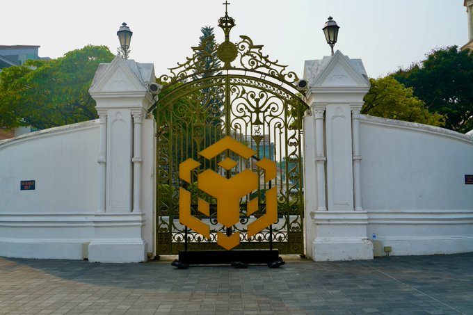 An ornate golden gate with an emblematic BNB (Binance Coin) logo stands at the entrance, symbolizing BNB SG's official launch event in Singapore, marking the gathering of builders, institutions, and community members shaping the future onchain.
