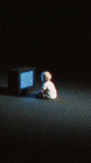 A child sits alone on the floor bathed in the blue glow of a television screen in an otherwise pitch-black room, visually embodying the theme of "addiction" from the @deltasauce Feed collection.