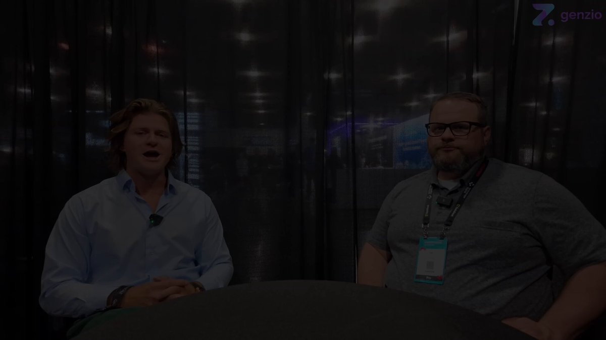 The image shows two men sitting at a table, with one man wearing glasses and the other wearing a lanyard around his neck. They appear to be engaged in conversation or discussing something related to privacy and decentralization. The background of the image is dark, which contrasts with the lighter colors on the screen where the post was published.