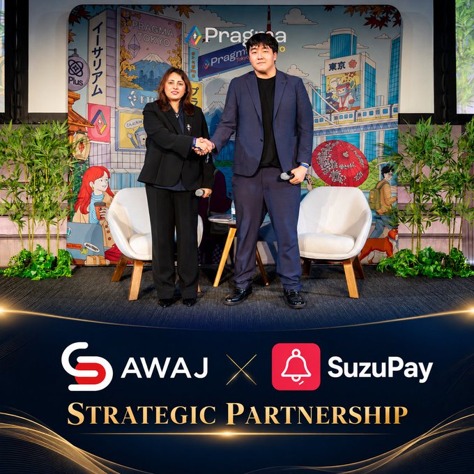 A promotional photo for a "Strategic Partnership" between "AWAJ" and "SuzuPay," showing a woman in black and a man in a blue suit shaking hands on a stage with a colorful illustrated backdrop including "Pragma Tokyo."