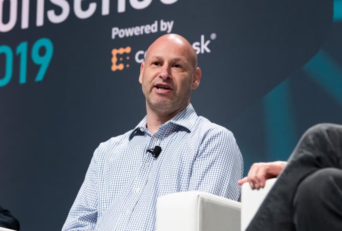 The image shows a man sitting down at a table with his hands resting on the table. He appears to be wearing a blue and white checkered shirt, which suggests he might have an interest in fashion or casual attire. The background of the image features a banner that reads "MetaMask agent wallet is less about “ai trading for you” and more about permission control that's the real unlock. This implies that the man may be discussing the concept of digital wallets, which are used to securely store payment information in exchange for virtual currency or other forms of digital assets. The image also includes a caption that reads "Focus on what is in the image and how it relates to the post."