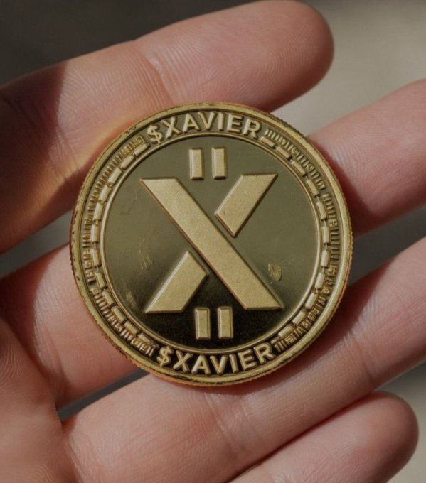 A hand holds a gold-colored $XAVIER cryptocurrency coin featuring a stylized X logo in the center.