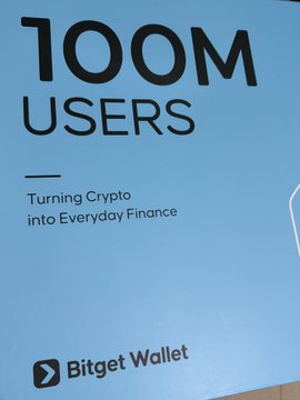 A promotional graphic by Bitget Wallet celebrating their achievement of surpassing 100M users, with the tagline "Turning Crypto into Everyday Finance." The bold "100M USERS" headline displayed against a blue background aligns with the accompanying post's congratulatory message about the platform's milestone and its comprehensive trading features.
