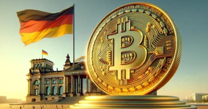 A large golden Bitcoin coin stands prominently in front of the Reichstag building in Berlin, with the German flag flying in the background.
