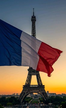 The French flag waves in the foreground with the Eiffel Tower silhouetted against a sunset sky in the background, symbolizing France. The image visually anchors the news that a French parliamentary committee has approved requiring disclosure of self-custody crypto wallets holding over €100,000, highlighting the regulatory developments coming out of France.