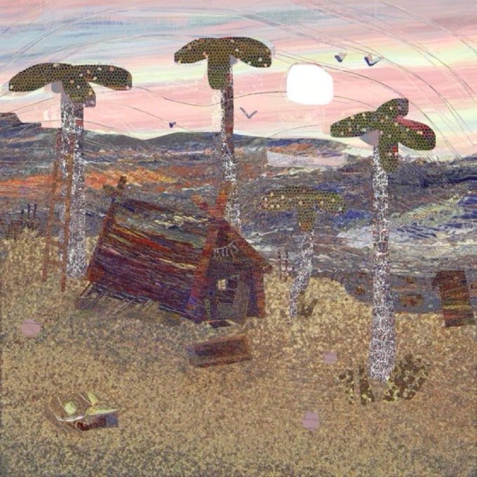 A textured mixed-media artwork depicting a desert landscape at sunset with a small cabin, tall cactus-like structures, and scattered objects on sandy ground.