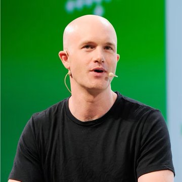 A bald man wearing a black t-shirt and an earpiece microphone speaks while seated in front of a green backdrop, likely during a panel or presentation. The image accompanies a post thanking someone for a short signal on $BTC, suggesting the man pictured may be a crypto trader or analyst known for market calls.