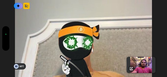 An animated ninja character wearing an orange Bitcoin headband and dollar-sign glasses appears on screen alongside a video call with a man in the corner, with "NFT" displayed in the interface, relating to a discussion about MetaDAOProject NFT initiatives.