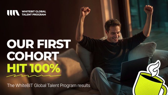 A man celebrates with his arms raised in triumph while looking at his laptop, promoting the WhiteBIT Global Talent Program with the headline "OUR FIRST COHORT HIT 100%" — highlighting the program's milestone of hiring all 11 selected participants from over 700 applicants, as described in the accompanying announcement.