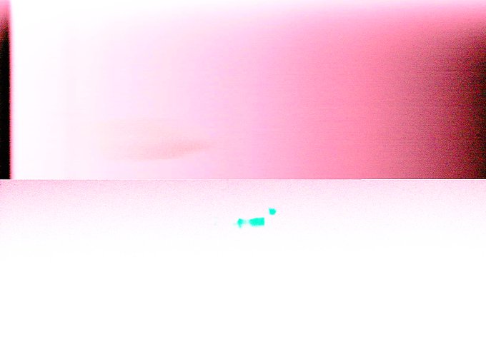 An overexposed pink and white image with faint dark shapes.