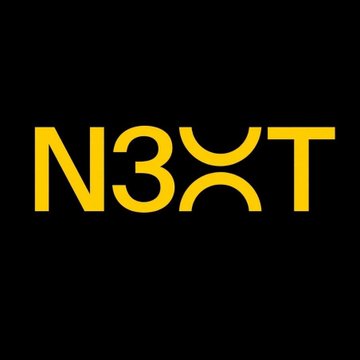 The image displays the "N3XT" banking logo in bold gold lettering on a black background, representing the new digital bank founded by former Signature Bank chair Scott Shay, which recently received Wyoming approval to offer blockchain-powered cross-border payment services.