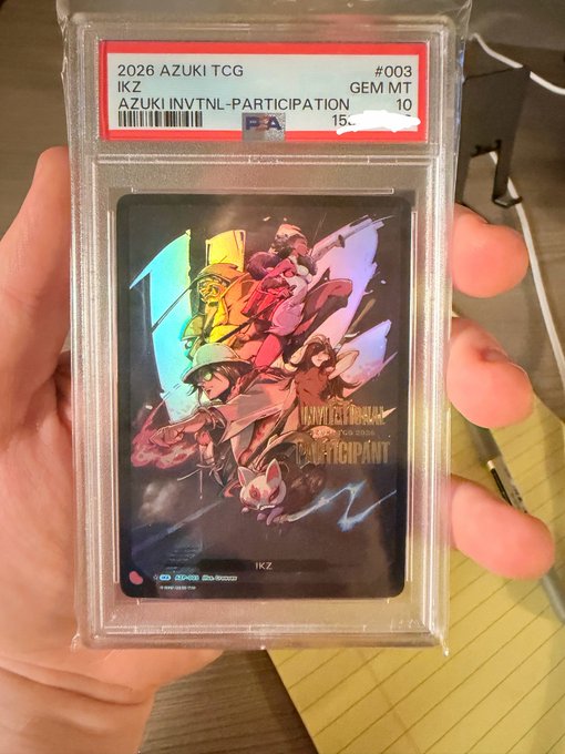 A PSA-graded trading card in a protective slab labeled '2026 AZUKI TCG, IKZ, AZUKI INVITNL-PARTICIPATION' graded GEM MT 10.
