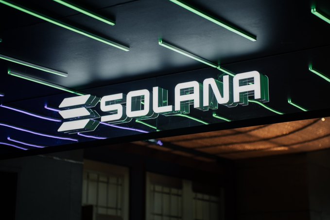 A glowing white "SOLANA" sign illuminates an outdoor venue entrance, accented by green and purple neon lighting—evoking the blockchain's signature color palette and setting the scene for BREAKPOINT, as the post highlights this week's milestones: Western Union's USDPT launch in Mexico, a second spot SOL ETF in Hong Kong, and a new partnership with Da Nang's Startup Support Centre.