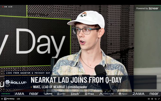 A live stream screenshot from 'The Rollup' titled 'NEARKAT LAD JOINS FROM Q-DAY' featuring a man in glasses and a patterned shirt, with 'LIVE FROM QUANTUM & PRIVACY DAY' text and various partner logos including Near, Plume, and Zama.