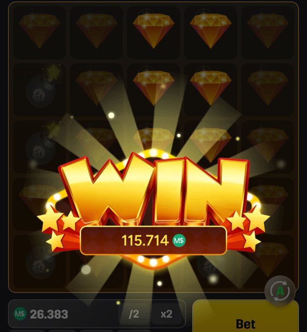 Mobile game "WIN" screen displaying a payout of 115.714 M$ with diamond symbols, showing a balance of 26.383 M$ and a Bet button.
