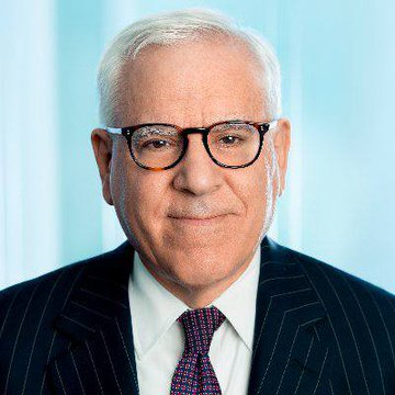 A headshot of billionaire investor David Rubenstein, who is featured in a post warning that U.S. debt has become a national security threat, with annual interest payments now exceeding national defense spending.
