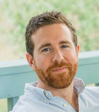 A man with a reddish beard and short hair, wearing a light blue button-up shirt, sits in front of a green chair in an outdoor setting. The image likely depicts James O'Beirne, the $BTC developer mentioned in the accompanying post about discovering Coldcard's RNG flaw.