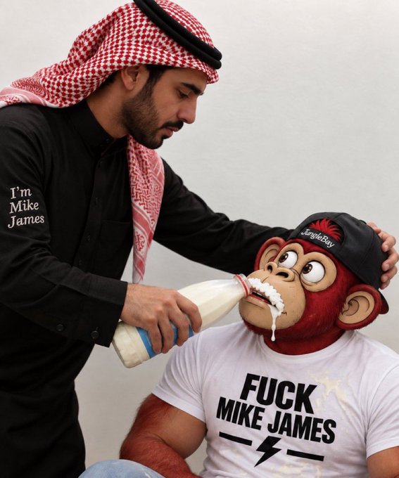 A man wearing a keffiyeh labeled 'I'm Mike James' pours milk from a bottle onto a person in a monkey mask and cap reading 'Jungle Boy', whose shirt says 'FUCK MIKE JAMES'.