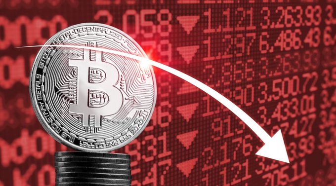 A silver Bitcoin ($BTC) coin sits on a stack of coins against a red stock ticker background, with a downward white arrow arcing across the image—visually reinforcing the post's warning that Bitcoin may drop below $80,000 toward $79,000.
