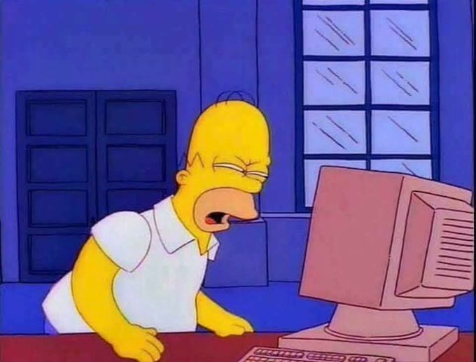 A meme image of Homer Simpson from The Simpsons angrily staring at an old CRT computer monitor in a blue-toned room.
