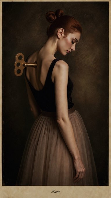An artistic portrait of a woman in a black top and flowing skirt, viewed from behind as she turns, with a large brass key extending from her back against a dark background, labeled 'time' at the bottom.