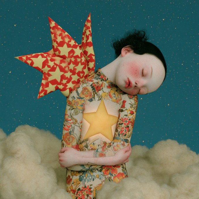 A surreal composite image of a sleeping child in a floral outfit with a yellow star on their chest, set against a starry teal sky and fluffy clouds, accompanied by a star-shaped origami balloon.