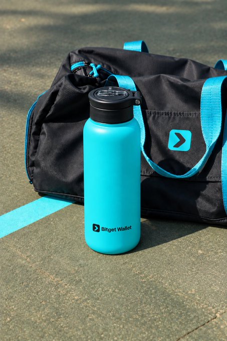 A turquoise water bottle branded "Bitget Wallet" sits on a green court next to a black and blue duffel bag featuring a similar logo.