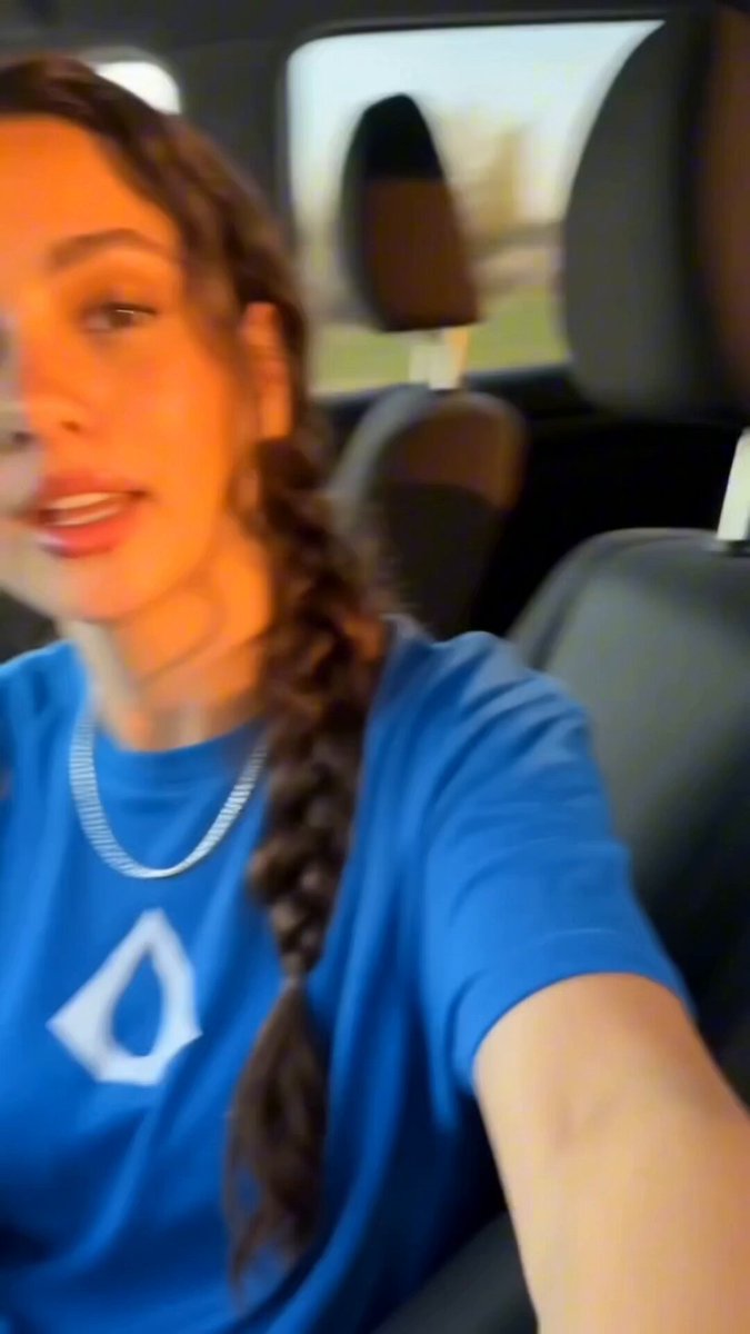 The image features a woman with long brown hair wearing a blue shirt, sitting inside a car. She has her arm out of the window while looking at the camera. The caption below the photo reads "Everyone is already getting their aqua.net Lightning Addresses! What are you waiting for?". This suggests that she might be excited about an upcoming event or gathering and wants to share it with others through social media.