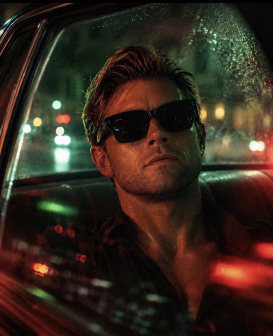 A man wearing sunglasses sits in a dimly lit car with rain-streaked windows and neon city lights glowing in the background, evoking a sleek, cinematic mood. The post references "@Gemini," tying the dual-toned lighting and mysterious styling to the Gemini zodiac sign's dual nature.