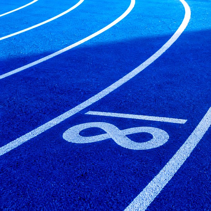 A vivid blue running track curves around a lane marked with a large white “8.” The image reinforces the accompanying post, “GM. Built for the long run.”, through its sports-track motif and symbol of endurance.