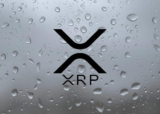 The XRP cryptocurrency logo displayed on a background of water droplets on glass.