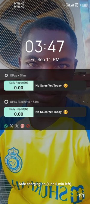 A phone lock screen selfie showing a young man in a yellow shirt with a fan behind him, displaying the time 03:47 PM on Friday, September 11, with OPay app notifications showing zero daily sales for both OPay and OPay Business.