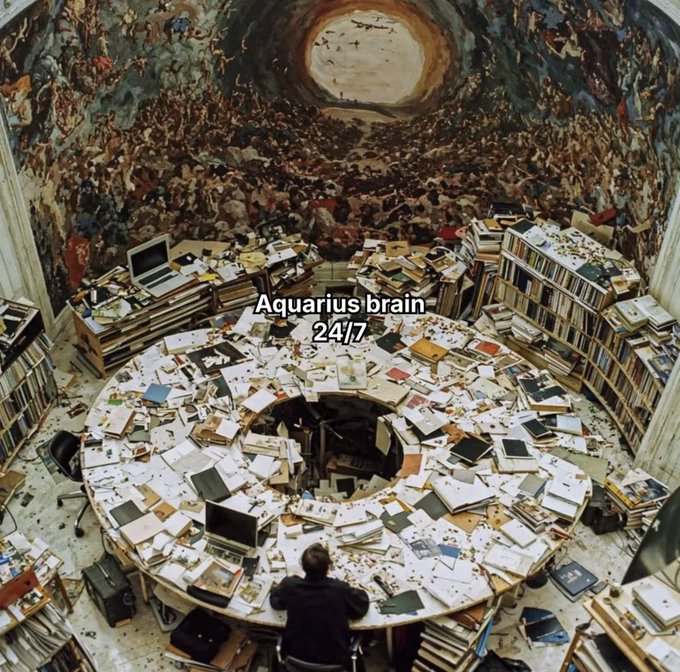 A surreal, chaotic image of a person sitting at a cluttered circular desk covered in books and papers, with text overlay reading 'Aquarius brain 24/7' and a fresco-style ceiling above.