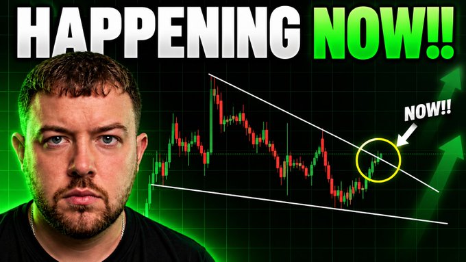 The image shows a YouTube thumbnail featuring a serious-looking man on the left against a dark background, with a Bitcoin candlestick chart displaying a downward channel pattern. Bold text at the top reads "HAPPENING NOW!!" in white and green, while a circled section of the chart is highlighted with an arrow pointing to "NOW!!" — emphasizing a potential breakout moment for Bitcoin that aligns with the post's urgent call to action.