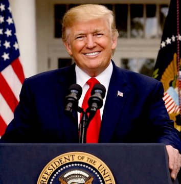 President Donald Trump stands at a podium bearing the Presidential Seal, smiling broadly as he addresses an audience with two microphones in front of him, framed by the American flag and another official banner. The setting aligns with the post's quote, suggesting he is delivering his pro-Bitcoin remark to supporters.