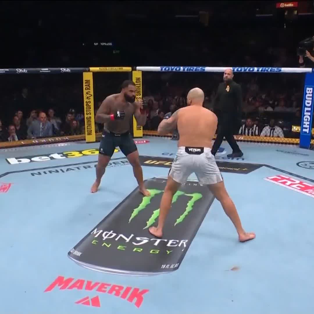 Two shirtless fighters square off in a UFC octagon with Monster Energy, bet365, and Bud Light sponsorship logos visible on the mat and padding. The image captures an early moment of the bout, likely just seconds into the fight before Sharaf Davlatov landed his devastating knockout punch at UFC 331.