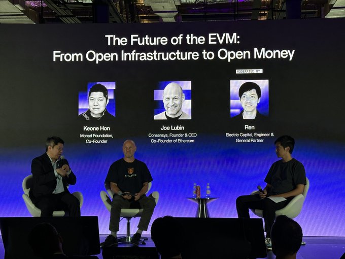 A panel discussion on stage titled 'The Future of the EVM: From Open Infrastructure to Open Money' featuring Keone Han (Monad Foundation, Co-Founder), Joe Lubin (Consensys, Founder & CEO, Co-Founder of Ethereum), and Ren (Electric Capital, Engineer & General Partner), moderated by Electric.