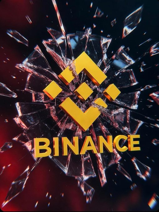 The image features a large, colorful logo for Bitcoin that has been shattered into many pieces of glass. The broken glass pieces are scattered across the image, with some pieces overlapping each other or falling off the frame. This fragmentation of the Bitcoin logo creates an abstract representation of the cryptocurrency's identity and value.