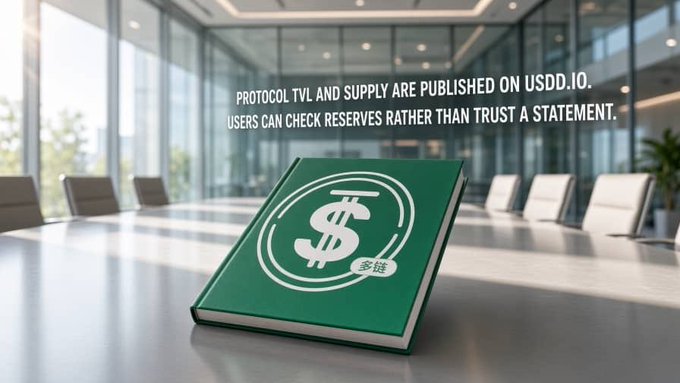 A green book with a dollar sign logo and Chinese text '多链' resting on a conference table, with overlay text reading 'PROTOCOL TVL AND SUPPLY ARE PUBLISHED ON USDD.IO. USERS CAN CHECK RESERVES RATHER THAN TRUST A STATEMENT.'
