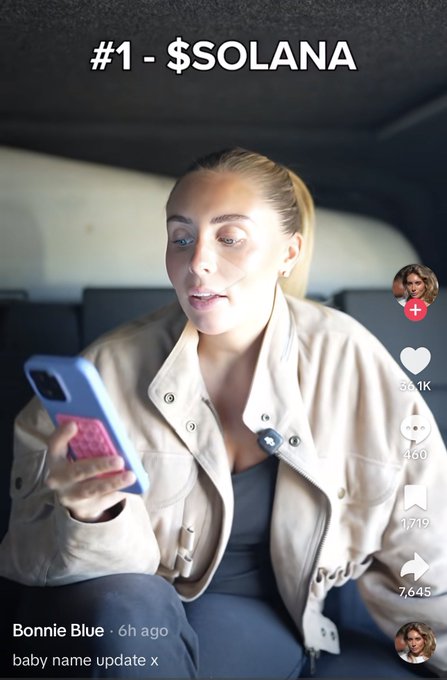 Bonnie Blue, wearing a beige jacket, looks at her phone while sitting in a car, with the text "#1 - $SOLANA" displayed at the top of the TikTok video, referencing the top-bid baby name in her auction. The caption reflects surprise that Solana ranked first and Alon second among the suggested baby names from fans.