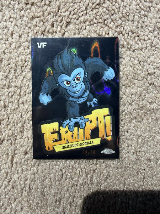 A trading card featuring a cartoon gorilla character with the text 'KRIPTI', 'GRATITUDE GORILLA', numbered 02/10, and 'Topps Chrome' logo, resting on a carpet.