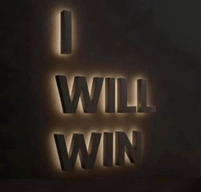 An illuminated 3D sign on a dark wall reads 'I WILL WIN' in glowing letters.