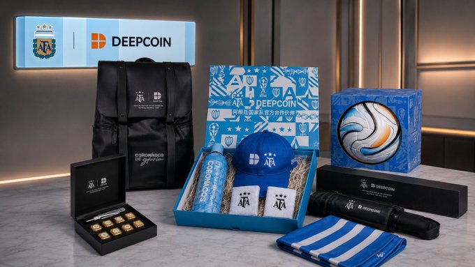 A promotional product display featuring a DEEPCOIN and AFA (Argentine Football Association) branded gift set, including a black backpack, a blue and white gift box with a cap and mug, chocolates, a scarf, and other merchandise.