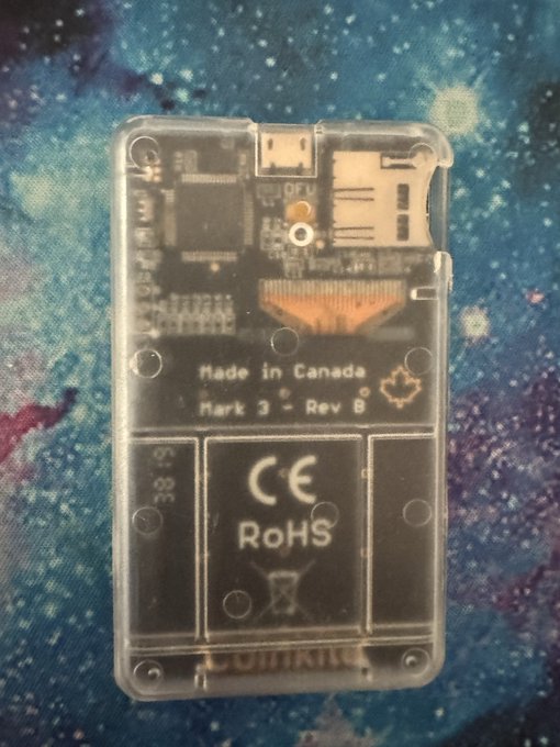 A transparent Coldcard hardware wallet (Mark 3 Rev 8) made in Canada, shown with its internal components visible through the clear casing, including CE, RoHS, and QFN markings. The post indicates the device is a Bitcoin/crypto "seed" storage device secured with an 8-digit PIN and two anti-phishing words rather than a passphrase.