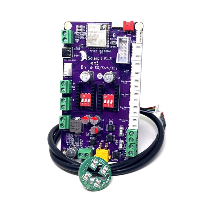 A purple circuit board labeled 'Solarbit V1.3' with various electronic components, DIP switches, terminal blocks, and an attached round green sensor with cables.