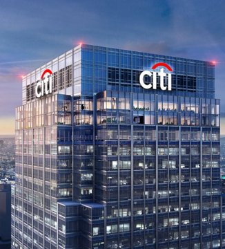 A towering glass skyscraper prominently displays the illuminated "citi" logo on its upper facade at twilight, representing Citibank's prediction that Bitcoin could reach $165,000, as the bank's corporate headquarters symbolizes the financial institution making the bullish cryptocurrency forecast.