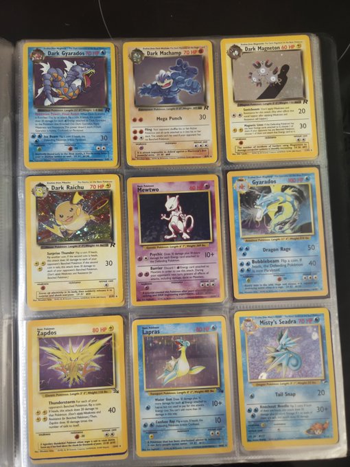 A nostalgic Pokémon card binder displaying 9 classic cards in protective sleeves, including holographic Dark Gyarados (70 HP), Dark Machamp (70 HP), Dark Magician (60 HP), Dark Raichu (70 HP), Mewtwo (60 HP), holographic Gyarados (100 HP), Zapdos (80 HP), Lapras (100 HP), and Misty's Seadra (70 HP), as featured in a nostalgic morning post suggesting a potential investment rotation into XRP.