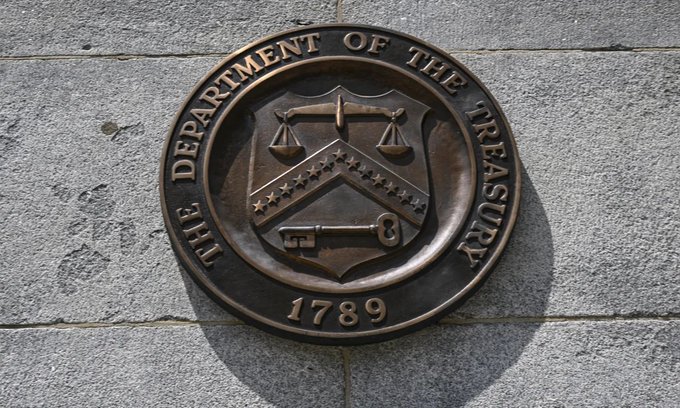 The official bronze seal of "The Department of the Treasury," dated "1789," mounted on a stone wall, symbolizing the U.S. Treasury's recent decision to expand its long-term debt buyback program, which has driven down 30-year and 10-year Treasury yields.