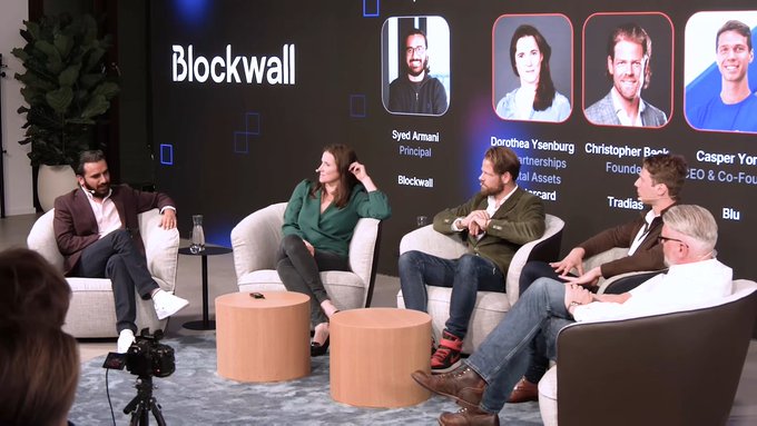 A panel discussion on stage at a Blockwall event, featuring speakers including Syed Armani (Principal, Blockwall), Dorothea Yesenburgh, Christopher Bernez, and Casper York (CEO & Co-Founder, Tradable/Blu).