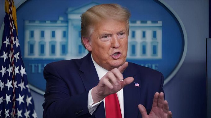 President Trump speaks at a podium in front of a backdrop depicting the White House and the American flag, relating to his supposed "BREAKING" statement about Bitcoin and crypto. The text "THE SE" is faintly visible on the backdrop.